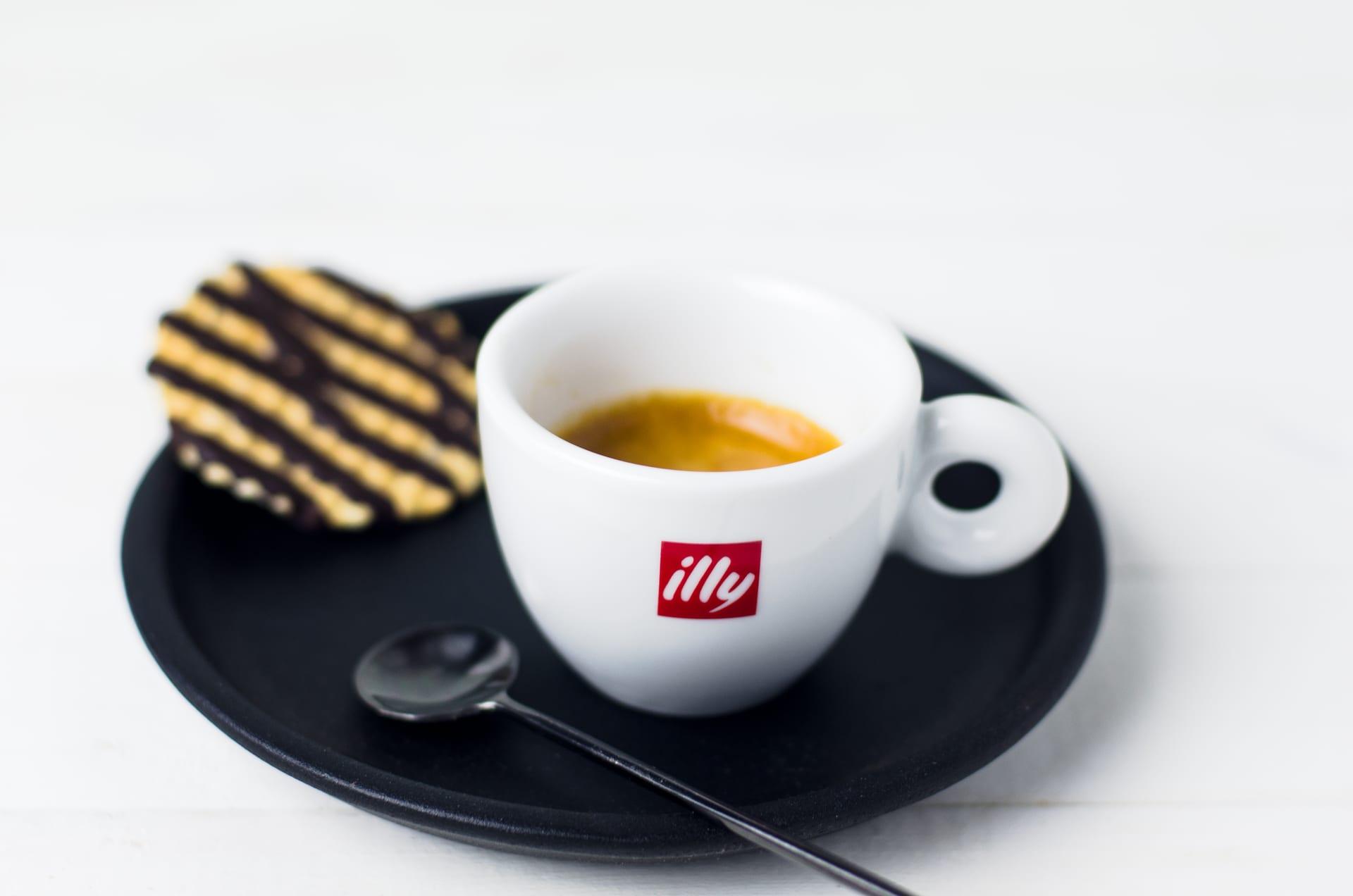 Illy espresso ar šokolādes vafeli uz tumšā šķīvja